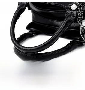 Detail of reinforced handles and stitching on black lychee texture leather handbag