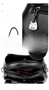 Detail view of black pebble leather handbag featuring metal hardware and spacious compartments