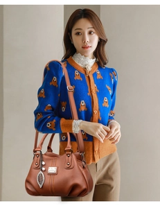 Brown lychee leather handbag featuring silver leaf pendant and detachable strap details