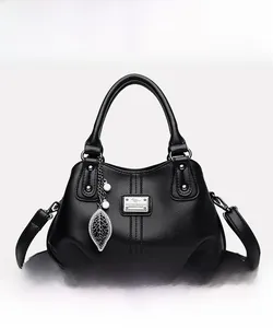 Detailed front view of black leather handbag with kangaroo logo and leaf pearl charm
