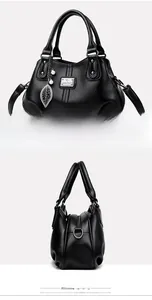 Detail view of black lychee-grain leather handbag with leaf pendant and soft pleats