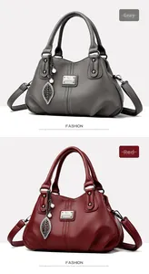 Close-up of gray and red textured leather handbags with pearl charms and brand logo
