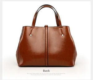 Detailed back view of dark brown oil wax leather tote bag with rivet decorations