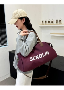 Detail of burgundy travel bag with leather handles and white SENGLIN logo text