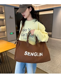 Detailed view of brown large-capacity travel tote bag with leather handles and logo