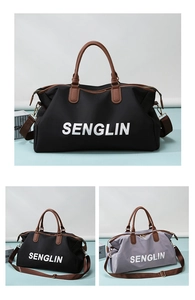 Detail view of large travel bags in black and grey with leather handles and shoulder straps