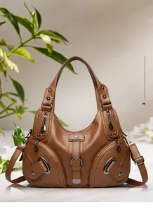 Dettaglio borsa a secchiello in pelle marrone con cerniere decorative e finiture in metallo