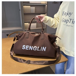 Detail view of large brown travel bag with white SENGLIN logo and adjustable strap