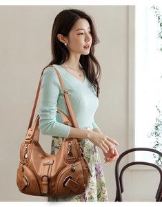 Vista dettagliata della borsa hobo grande in pelle marrone con cerniere e tracolla
