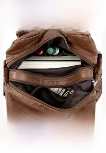 Detail view of large brown leather tote with multi-compartment interior and functional pockets