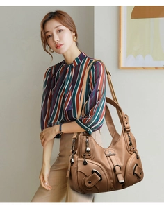 Dettaglio borsa hobo marrone scuro con fibbia vintage, tasche e trama litchi fine
