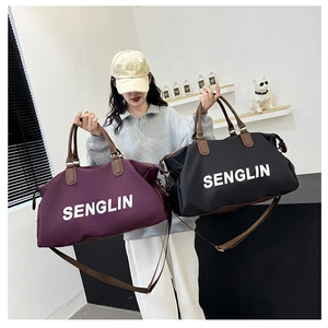 Detail of purple and black nylon travel bags with leather handles and SENGLIN logo