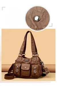 Detail of brown vintage PU leather bag featuring silver logo and functional zip pockets