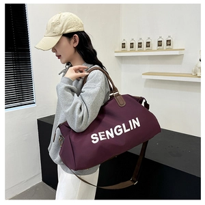 Detailed view of durable waterproof nylon fabric and leather handle on purple duffel bag