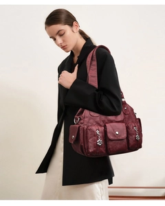 Detail view of burgundy vintage shoulder bag featuring multiple functional utility pockets
