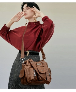 Detailed view of the brown vintage crossbody bag with multiple pockets on a model