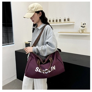 Detail view of large purple travel bag with brown handles and Senolin print