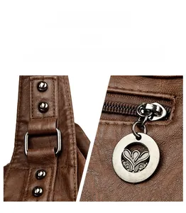 Detail of dark brown leather handbag featuring silver metal hardware and engraved floral charms