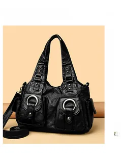 Detail of black pleated PU leather tote bag with silver metal rings and twin front pockets