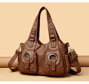 Close-up of vintage dark brown handbag with metal ring accents and reinforced handles