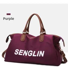 Detailed close-up of large purple travel bag with leather handles and white logo