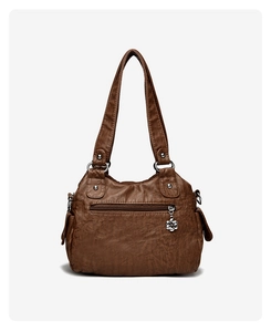 Close-up of vintage brown leather tote bag with silver flower charm and zip pocket