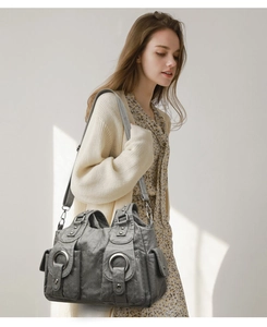 Detail of grey retro satchel with metal rings and pockets on vintage style soft leather