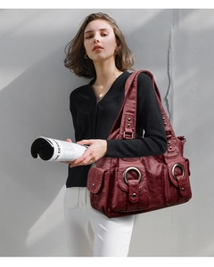 Detail of burgundy leather tote bag featuring two front pockets and large silver ring hardware