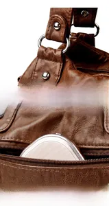Detail of brown litchi grain leather texture, silver hardware and functional back zipper pocket