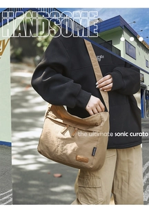 Detail of khaki nylon messenger bag with brand leather label and water-resistant texture