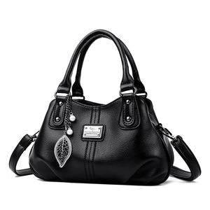 Black pebbled leather tote bag with pearl leaf charm and detachable shoulder strap