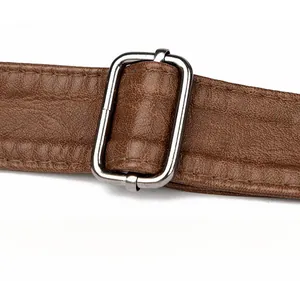 Detail of adjustable silver buckle and brown pebbled leather strap on shoulder bag