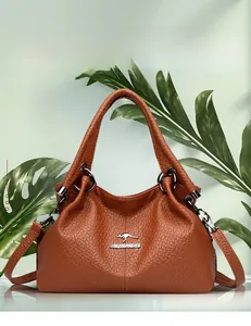Detail of soft lychee grain leather handbag with gold kangaroo emblem and metal logo