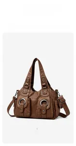 Detail of vintage brown leather tote bag showing magnetic flap pockets and metal rings