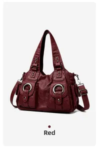 Detailed view of dark red PU leather handbag with two front pockets and silver ring decor