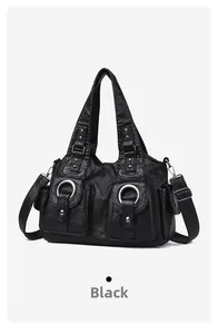 Detail of black vintage soft leather handbag with metal rings and functional pockets