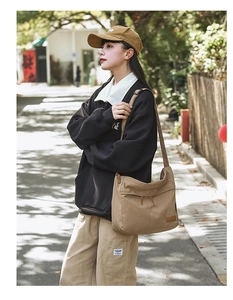 Outdoor shot of a large khaki messenger bag with zipper compartments in Japanese style
