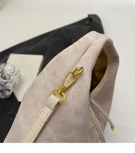 Close-up of light pink textured fabric handbag with premium gold hardware and drawstring