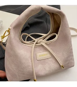 Detail of lavender handbag featuring a bow tie design and textured twill fabric