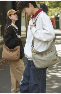 Close-up of adjustable straps and leather logo detail on durable nylon messenger bags
