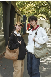 Outdoor shot of models wearing large canvas crossbody bags in khaki and green