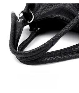 Detail of black pebbled leather shoulder strap with silver metal rings on a tote bag