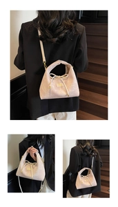 Close-up of beige pink hobo bag featuring decorative bow drawstring and gold logo plaque