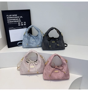 Detail of minimalist suede handbags with drawstring bows in multiple fashion colors
