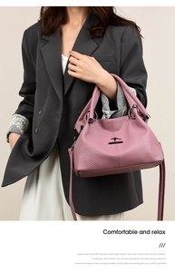 Detail of soft lychee texture and golden kangaroo logo on a dusty pink handbag