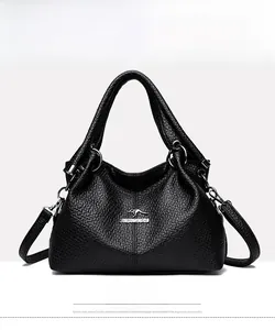 Front view of black embossed leather shoulder bag with circular metal handle and logo
