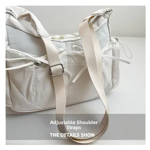 Détail de la bandoulière réglable avec boucle en métal sur un sac en nylon blanc décontracté