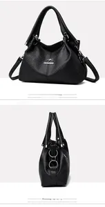 Detail view of black lychee-grain leather handbag featuring kangaroo logo and stitching