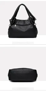 Detail view of the black textured leather shoulder bag showing back pocket and flat bottom