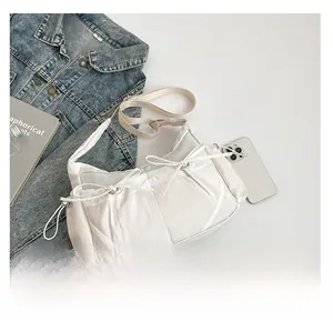Détail du sac demi-lune en nylon blanc avec nœuds décoratifs et bandoulière